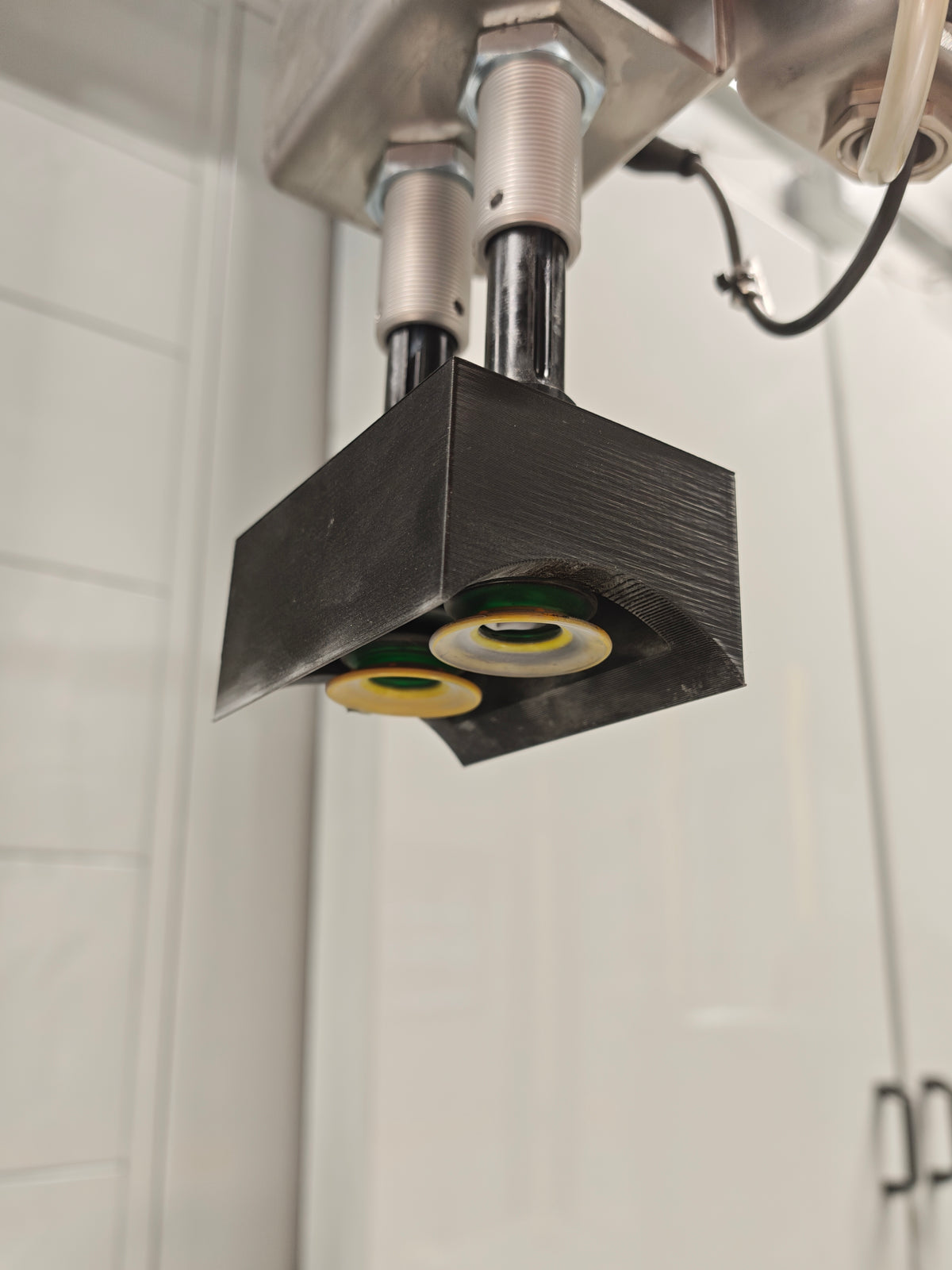 Boîtier noir imprimé en 3D installé autour de deux galets sur une machine